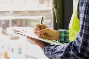 Young,man,contractor,,engineering,or,employee,holding,,clipboard,,looking,at